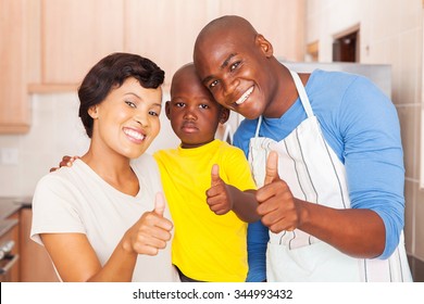 happy young african family giving thumbs up in kitchen