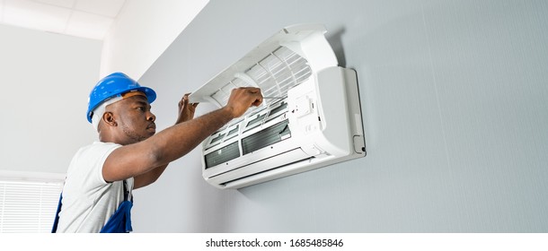 Happy Young African Male Technician Repairing Air Conditioner