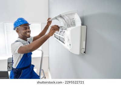 Happy Young African Male Technician Repairing Air Conditioner - Powered by Shutterstock