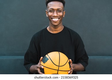 Happy young African man playing basketball outdoor - Urban sport lifestyle concept