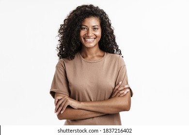 Happy young african woman casually dressed standing isolated over white background, arms folded