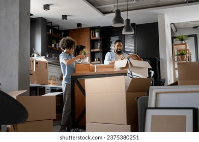 Happy young African-American family husband, wife, and teen son just moved into a new home unpacking. Relocation - Powered by Shutterstock