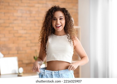 Happy Young African-American Woman In Loose Clothes At Home. Diet Concept