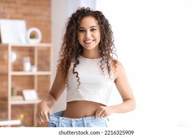 Happy Young African-American Woman In Loose Clothes At Home. Diet Concept