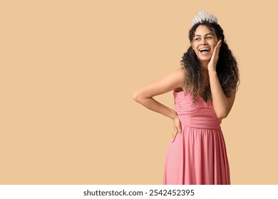 Happy young African-American woman in stylish pink prom dress and tiara on brown background - Powered by Shutterstock