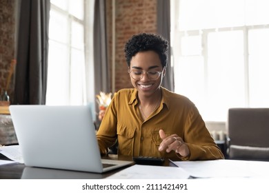 Happy junge Afro-amerikanische Unternehmerin in Brille, die Gewinn zählt, auf dem Rechner des Laptops, die Analyse der Vorteile, der finanzielle Erfolg, Job-High-Ergebnis, Lächeln
