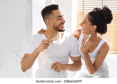 Happy Young Arab Spouses Having Fun While Brushing Teeth In Bathroom Together, Portrait Of Happy Middle Eastern Couple With Toothbrushes In Hands Making Morning Dental Hygiene At Home, Closeup