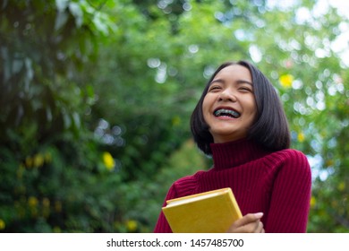 Happy Young Asain Girl Hold Notebook With Green Background.