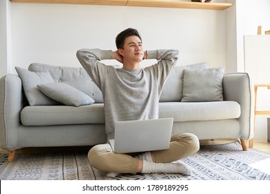 Happy Young Asian Business Man Staying At Home Sitting On Carpet Working Using Laptop Computer Happy And Smiling