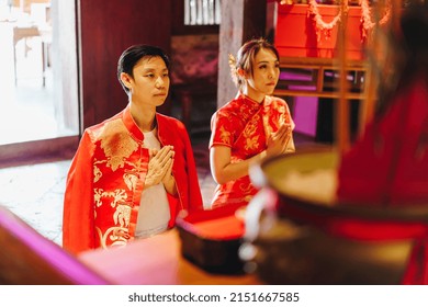 Happy Young Asian Couple Love In Chinese Traditional Dresses Praying At Chinese Temple