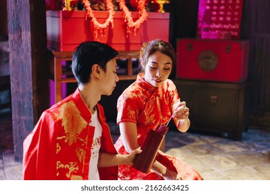 Happy Young Asian Couple Love In Chinese Traditional Dresses Praying At Chinese Temple