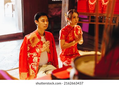 Happy Young Asian Couple Love In Chinese Traditional Dresses Praying At Chinese Temple