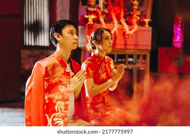 Happy Young Asian Couple Love In Chinese Traditional Dresses Praying At Chinese Temple