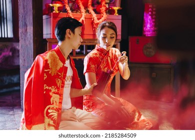 Happy Young Asian Couple Love In Chinese Traditional Dresses Praying At Chinese Temple