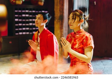 Happy young Asian couple love in Chinese traditional dresses praying at Chinese temple - Shutterstock ID 2246581963