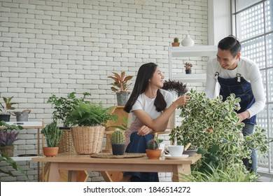 Happy young Asian couple wearing apron uniforms gardening and take care of their plants together at home - Powered by Shutterstock