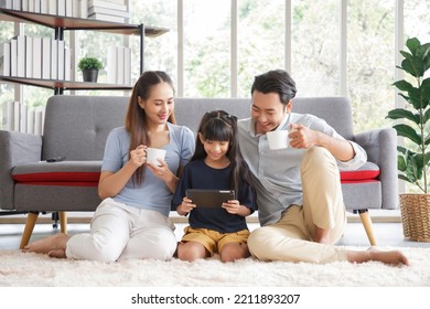 Happy young asian family mom and dad with daughter having fun in liviing room at home, while daughter using tablet. Family,love and happiness concept. - Powered by Shutterstock