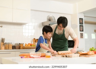 Happy Young Asian father and son cooking in kitchen at home  - Powered by Shutterstock