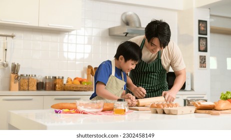 Happy Young Asian father and son cooking in kitchen at home  - Powered by Shutterstock