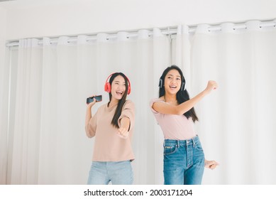 Happy Young Asian Lesbian Couple Listening To Music And Dancing Together At Home,LGBT Concept