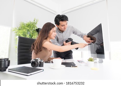 Happy Young Asian Man Professional Photographer And Woman Graphic Designer Checking A Picture On Display While Working Together In The Modern Office. Business Creative People, Teamwork Concept.