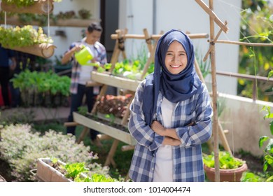 Happy Young Asian Muslim Woman In Rooftop Garden. Small Urban Farming