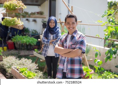 Happy Young Asian People In Rooftop Garden. Small Urban Farming Concept