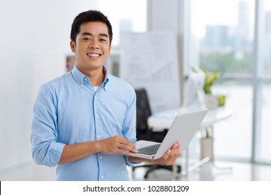 Happy Young Asian Software Developer With Laptop In His Hands