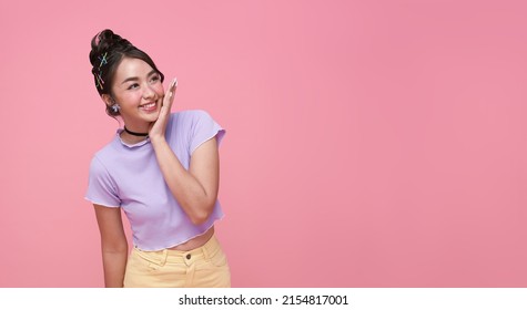 Happy young Asian teen woman looking at copy space on pink background. - Powered by Shutterstock