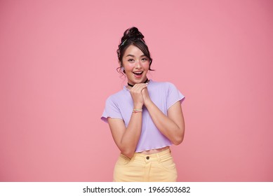 Happy young Asian teenage girl on pink background.