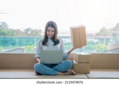 Happy Young Asian Woman Entrepreneur, Smile For Sales Success After Checking Order From Online Shopping Store In A Laptop At Home Office, Concept Of Merchant Business Online And ECommerce