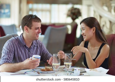 Happy Young Asian Woman WIth European Young Male Friend in the Restaurant - Shutterstock ID 580645810