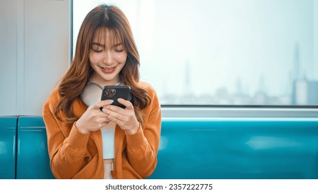 Happy young Asian woman passenger smile and using smart mobile phone in subway train station, lifestyle, transportation. - Powered by Shutterstock