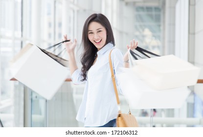 Happy Young Asian Woman Shopping With Motion Blur.