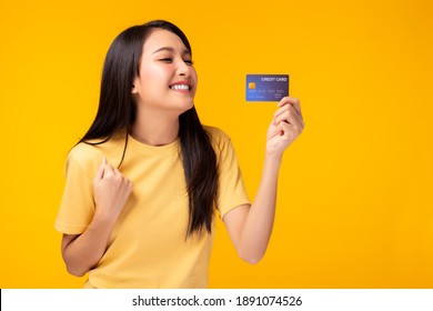 Happy Young Asian Woman Showing Plastic Credit Card And Looking At Credit Card With Happy Standing Over Yellow Background Customer Girl Get Satisfied Of Credit Card Service With Smile On Face