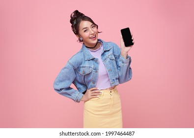 Happy Young Asian Woman Showing At Blank Screen Mobile Phone And Hand Gesture Success Isolated Over Pink Background.