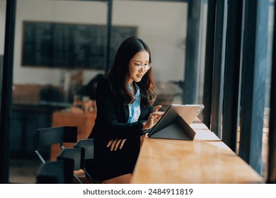 Happy young asian woman, using digital tablet isolated on office background - Powered by Shutterstock