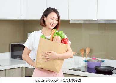 Happy Young Asian Woman With Vegetables In Shopping Bag. Diet Concept. 