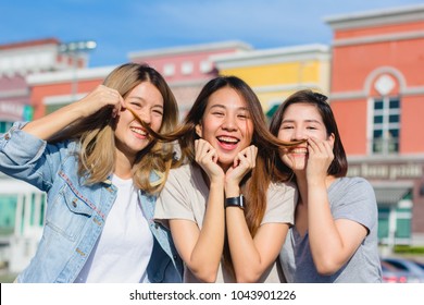 Happy Young Asian Women Group City Lifestyle Playing And Chatting Each Other Among The Pastel Building City On Weekend. City Lifestyle Of Girls Group. City Lifestyle And Outdoor Activity Concept.