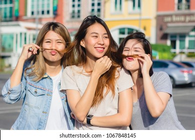 Happy Young Asian Women Group City Lifestyle Playing And Chatting Each Other Among The Pastel Building City On Weekend. City Lifestyle Of Girls Group. City Lifestyle And Outdoor Activity Concept.