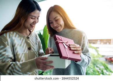 Happy Young Asian Women Opening A Gift Box Together