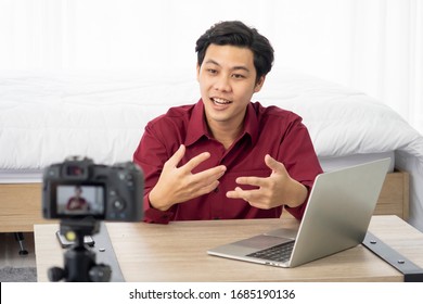 Happy young attractive Asian influence male vlogger talking and smile for live streaming, broadcast with internet subscribers. Social media people , content maker, e-commerce concept. working at home.