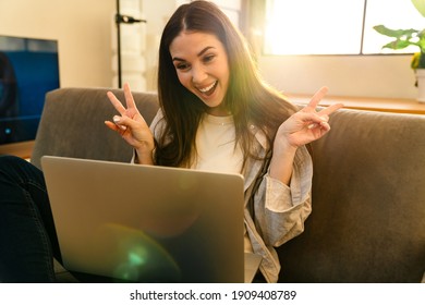 Happy Young Attractive Woman Looking At Laptop Screen, Waving Hands, On A Video Call With Friends From Home