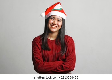 Happy young beautiful asian woman wearing christmas hat and red dress isolated on white background. christmas concept.
