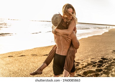 Happy young beautiful couple having fun on the beach during sunset, hugging and smiling. Summer vibes. Real people emotions and lifestyle. - Powered by Shutterstock