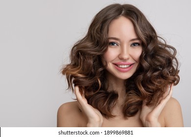 Happy Young Beautiful Woman With Curly Hair. Grey Background