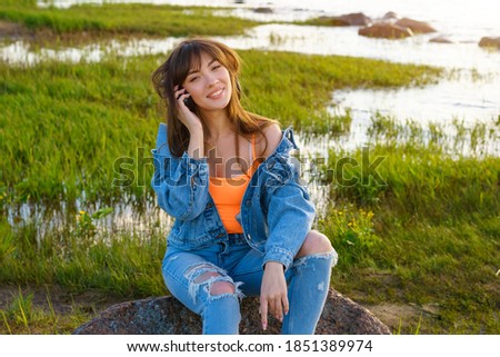 happy young beautiful woman with headphones listening to music on the Bay