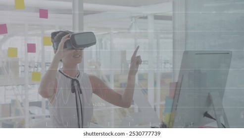 A happy young biracial female business creative working in a modern office, in a vr headset and touching a virtual screen. Global digital interface technology and social media concept digitally - Powered by Shutterstock