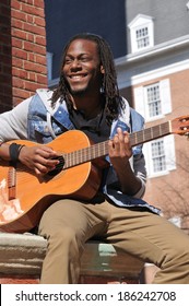 Happy Young Black Man Playing The Guitar In The City