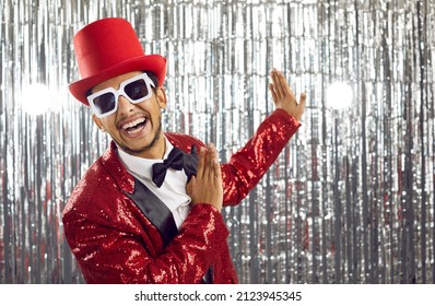 Happy young black man in red disco jacket dance on glitter background. Smiling African American entertainer or showman have fun on party or celebration in nightclub. Entertainment concept. - Shutterstock ID 2123945345